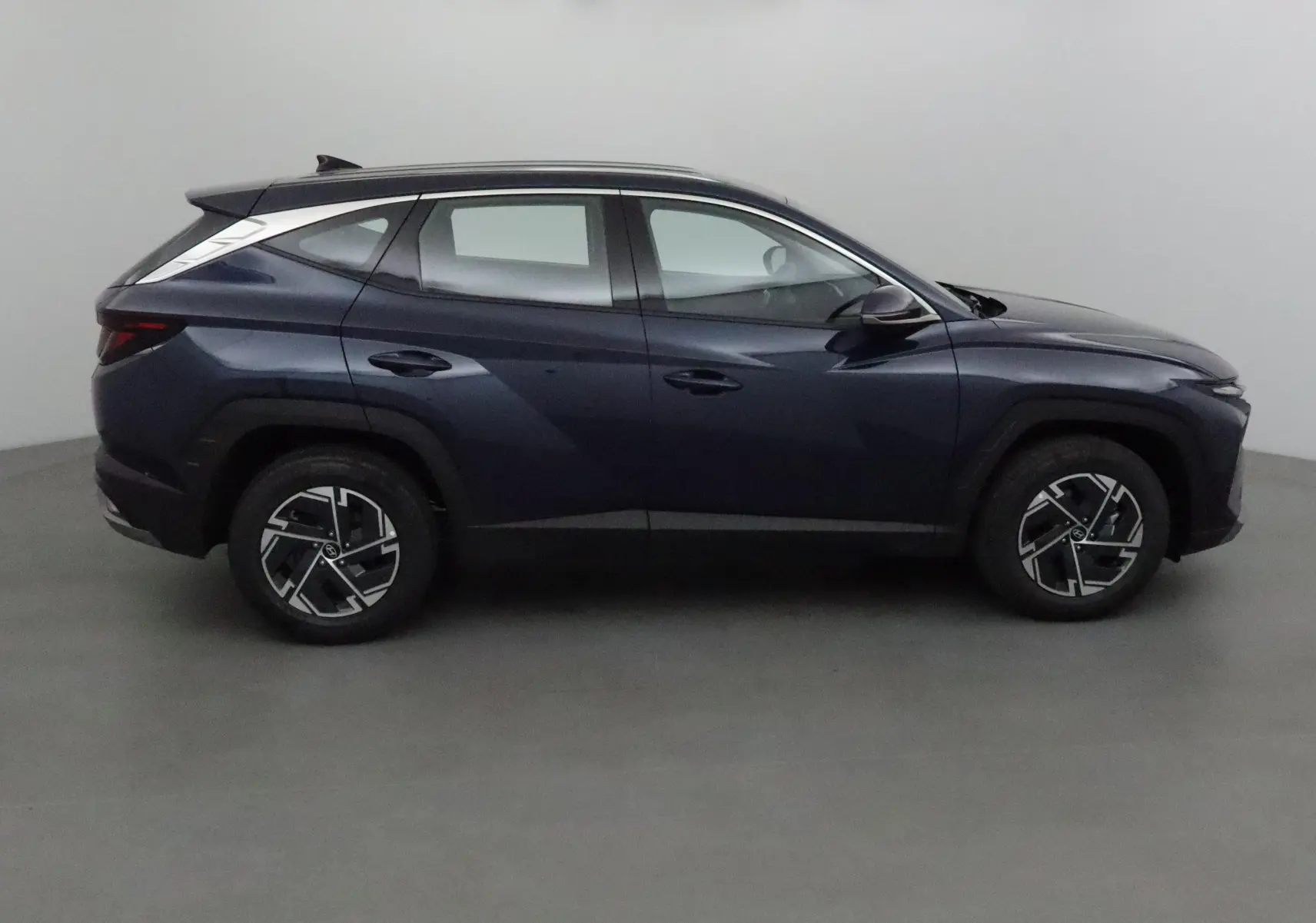 Profil côté gauche du Hyundai Tucson 2025 bleu Salling, soulignant ses lignes modernes et ses jantes alliage noires.