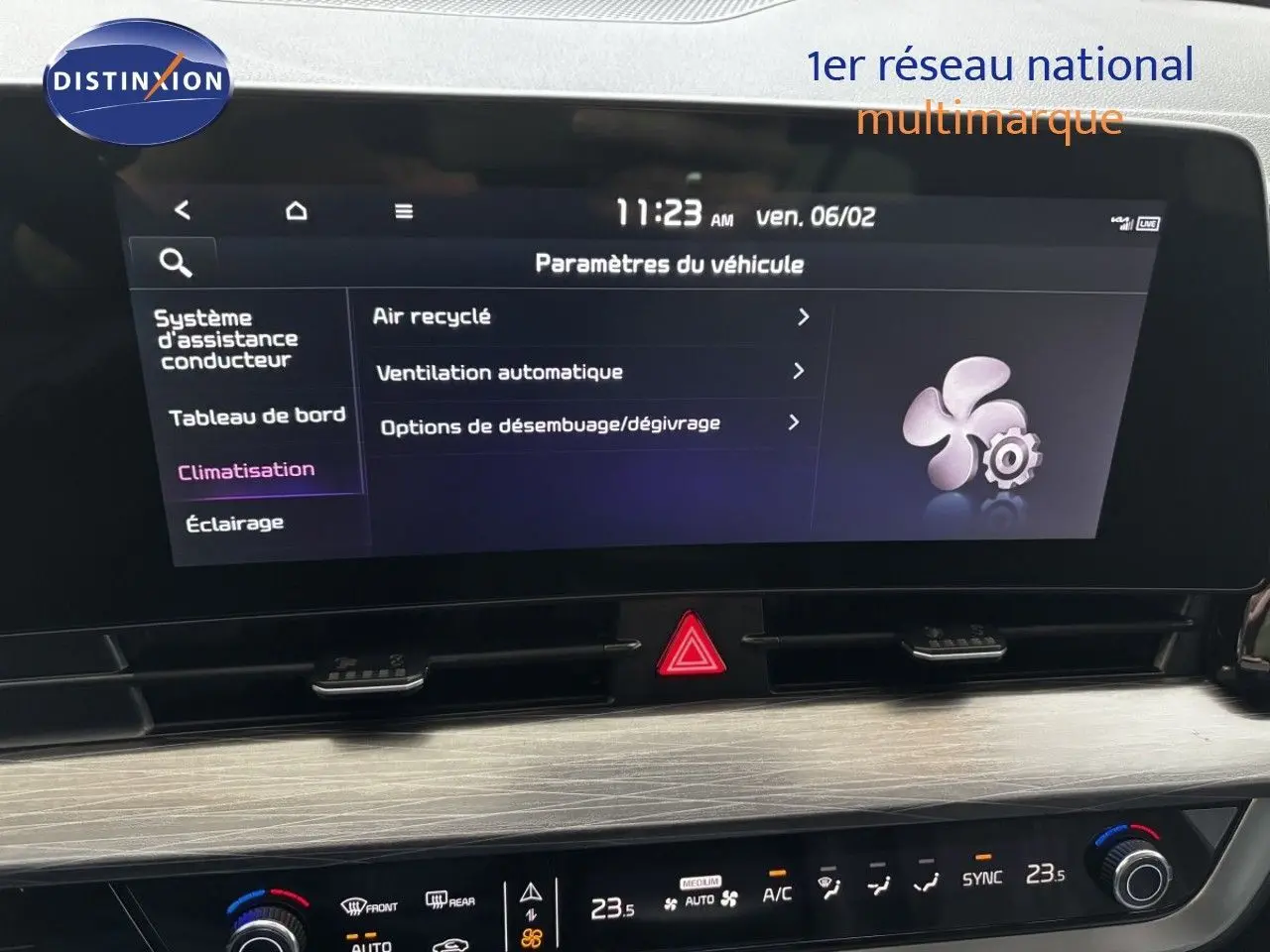 Écran tactile central et commandes de climatisation du Kia Sportage blanc nacré, vue intérieure frontale rapprochée.