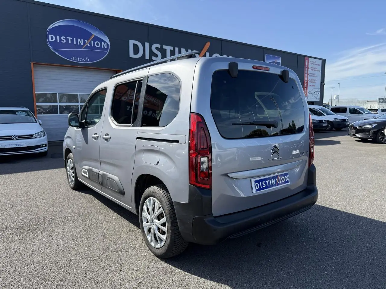Vue 3/4 arrière droite d'un Citroën Berlingo gris foncé avec vitres arrière surteintées et lunette ouvrante.