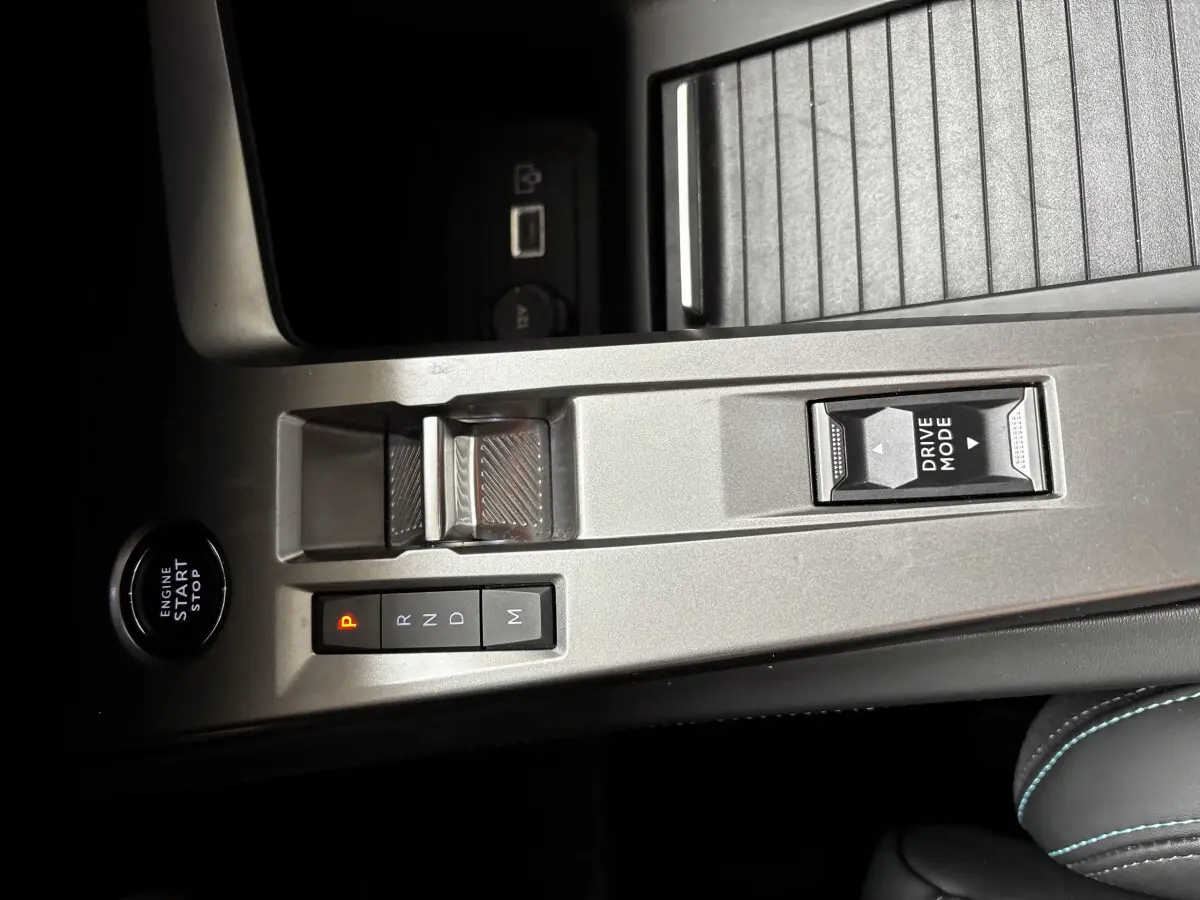 Vue rapprochée de la console centrale argentée avec bouton start, sélecteur de boîte auto et commande Drive Mode d'une Peugeot 308 noire.