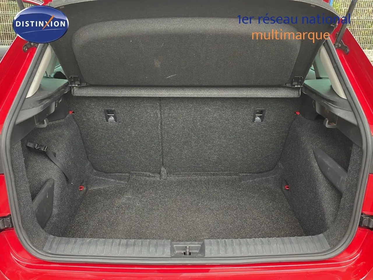 Coffre ouvert d'une Skoda Kamiq rouge Velvet Metal 2024, vue arrière montrant l'espace de chargement vide et doublure grise.