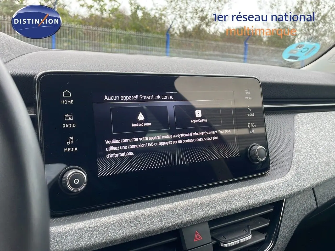 Écran tactile central du tableau de bord du Skoda Kamiq rouge Velvet Metal, affichant les options Android Auto et Apple CarPlay.