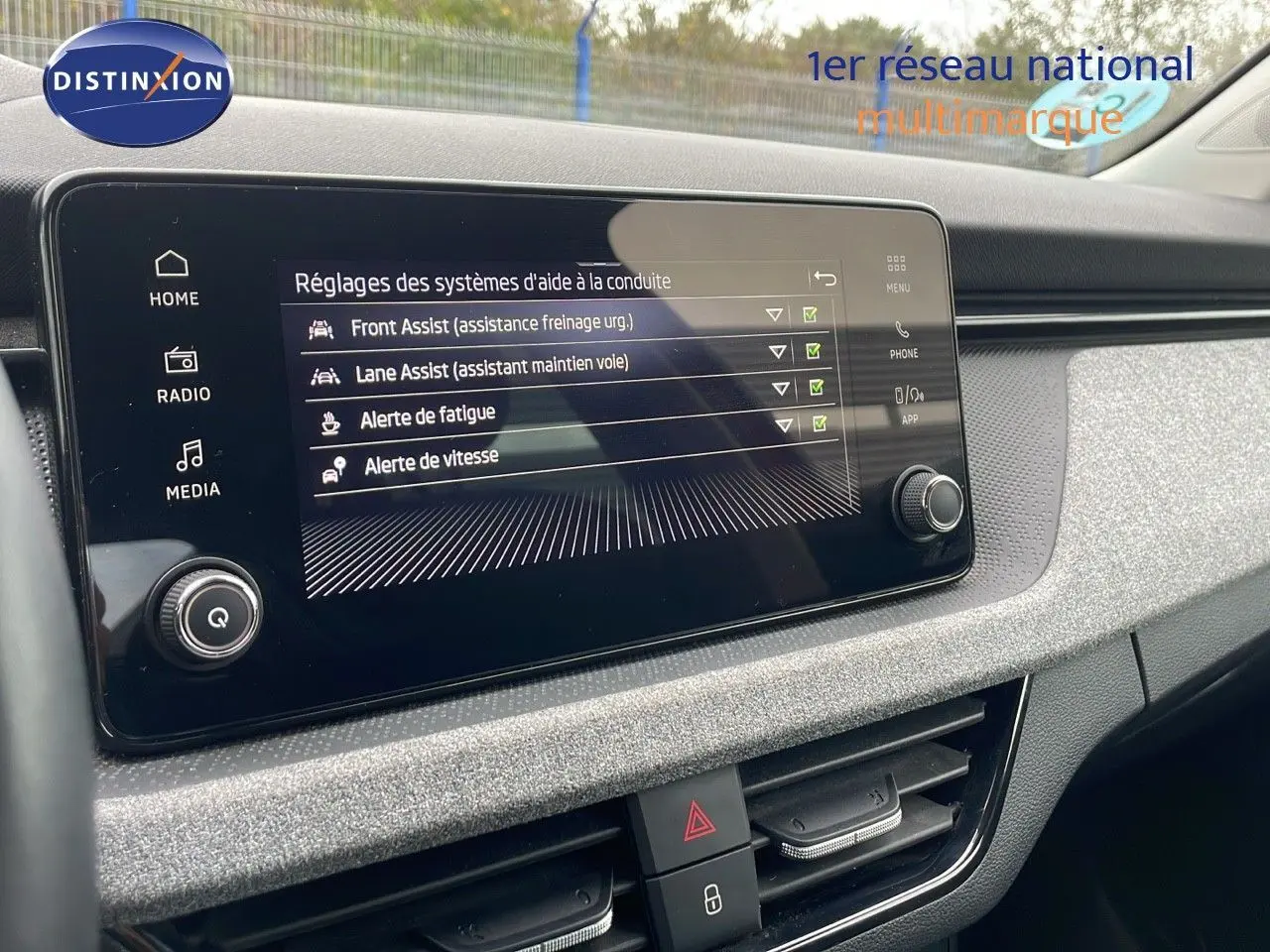 Écran tactile central affichant les réglages d'aides à la conduite dans le tableau de bord du Skoda Kamiq 2024.