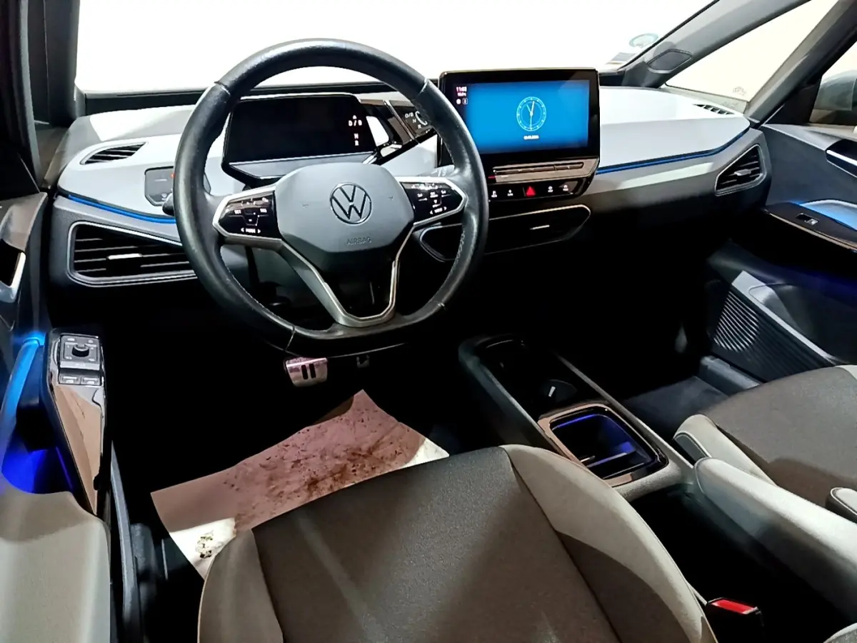 Vue intérieure avant du Volkswagen ID.3 77 kWh Pro S 2022, tableau de bord gris clair avec écran tactile central lumineux.