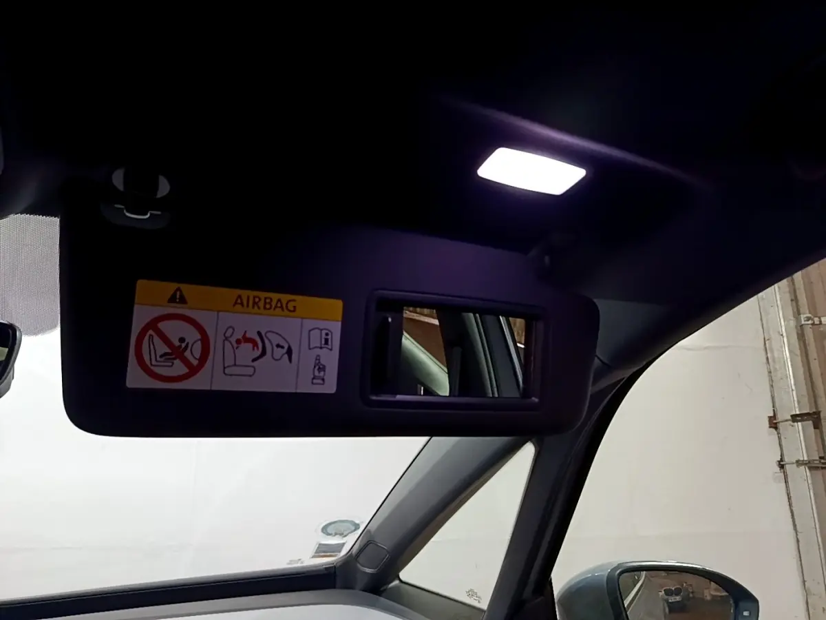 Miroir de courtoisie éclairé sur pare-soleil côté conducteur dans l’habitacle gris foncé d’une Volkswagen ID.3 77 kWh Pro S.