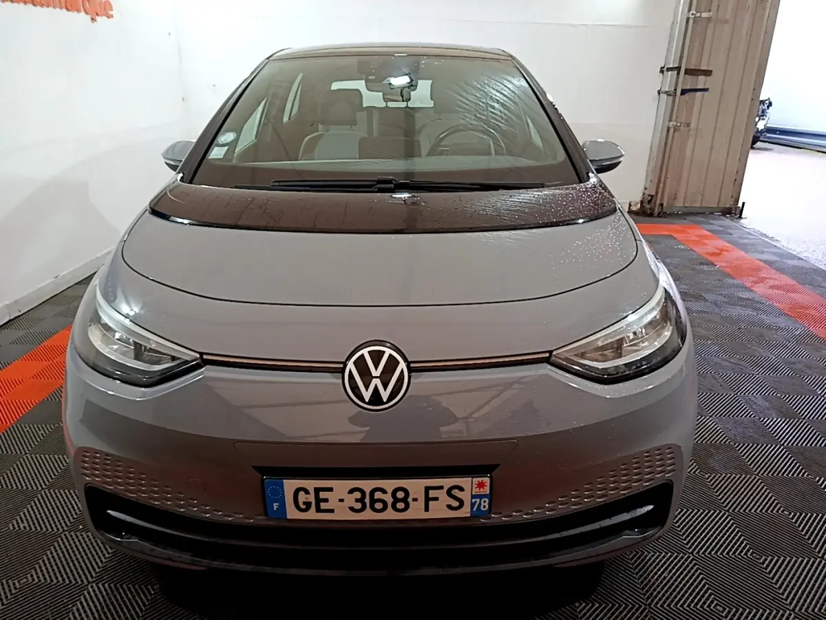 Vue avant d'une Volkswagen ID.3 77 kWh Pro S gris foncé avec logo VW et phares LED dans un garage.
