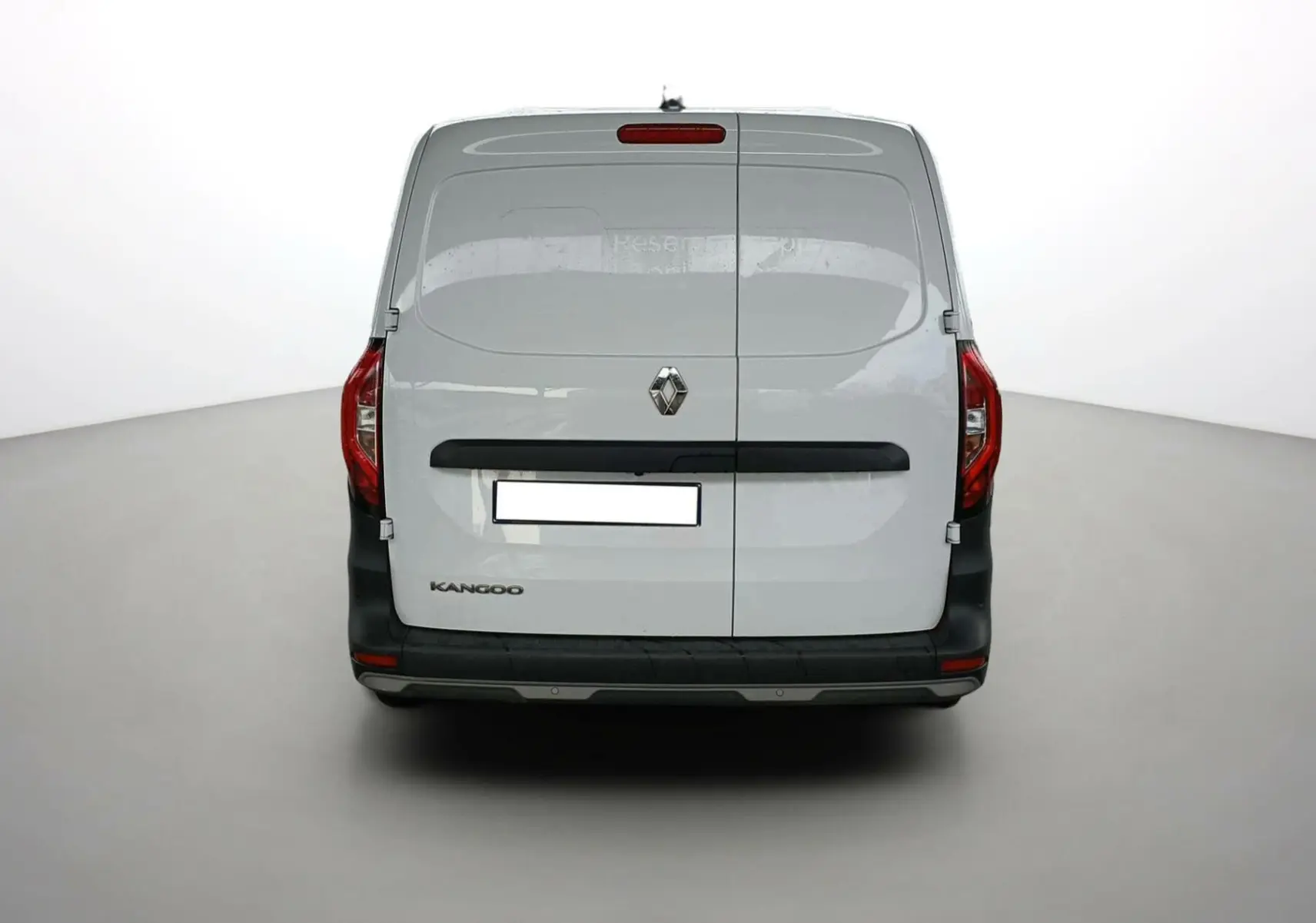 Vue arrière d’un Renault Kangoo Van blanc 2024 avec portes battantes et feux arrière rouges visibles.