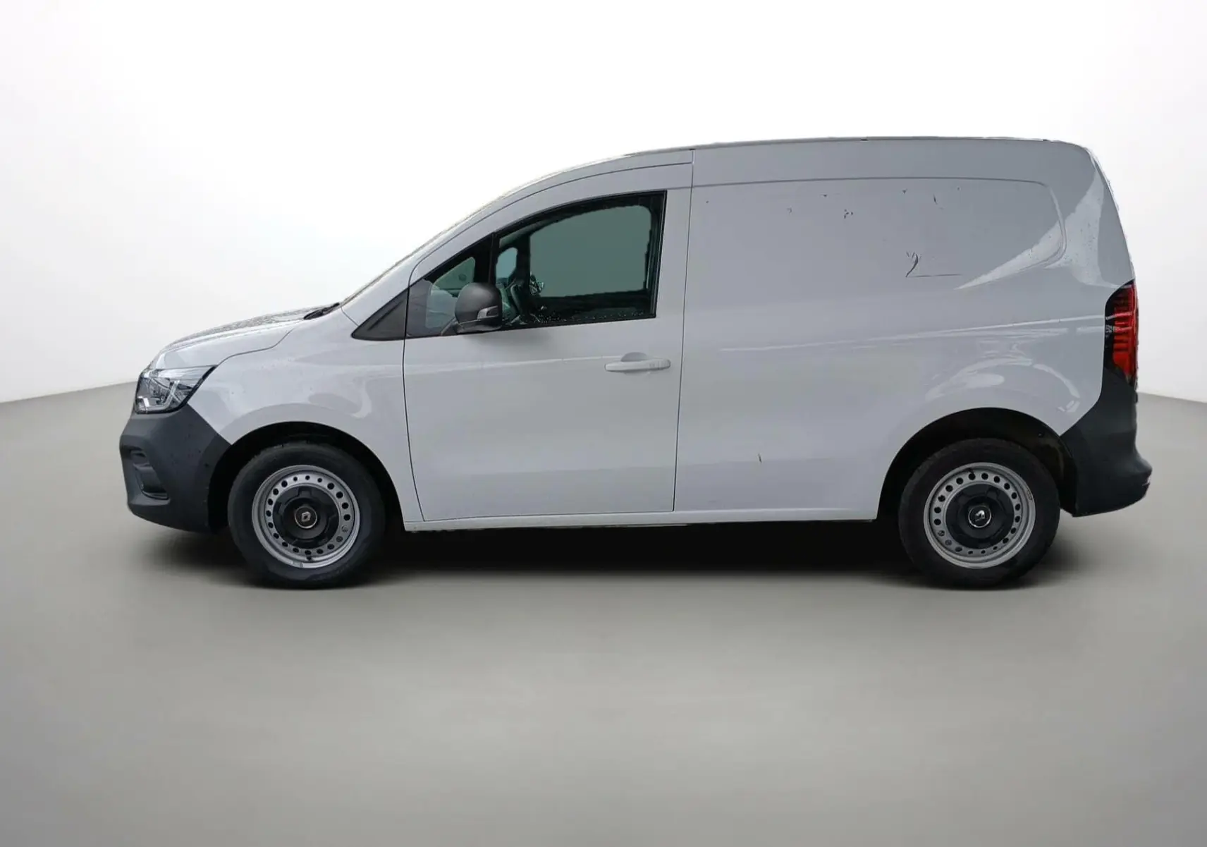 Profil droit d'un Renault Kangoo Van blanc 2024 avec portes latérales pleines et jantes acier simples.
