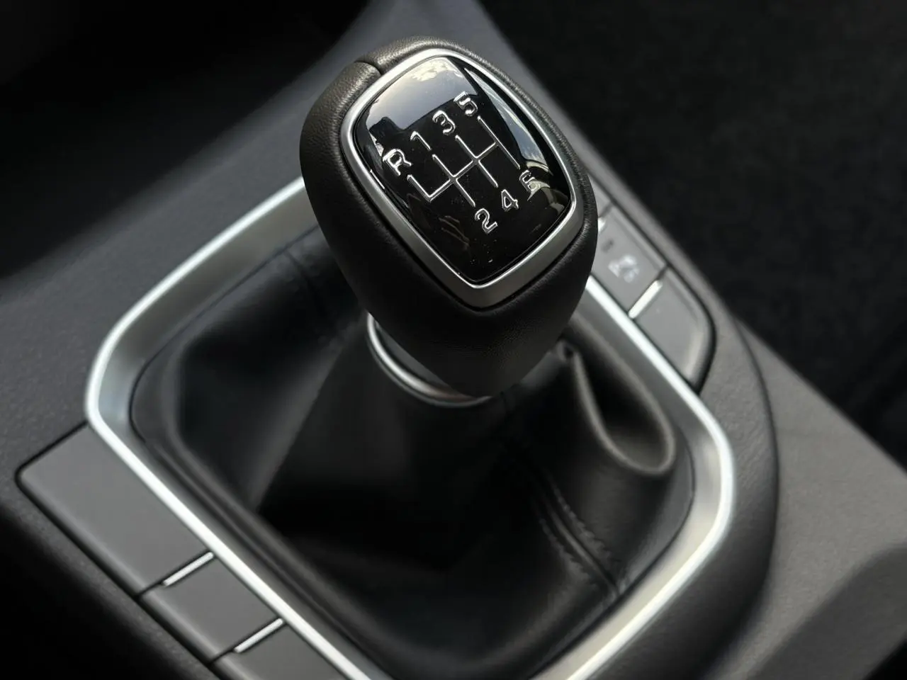 Gros plan sur le levier de vitesses manuel cuir noir de la Hyundai i30 SW T-GDI 120 Modern, intérieur moderne.