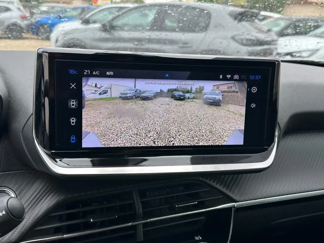 Écran tactile intérieur du Peugeot 2008 Hybrid 136 Allure montrant la caméra de recul avec vue arrière sur gravier.