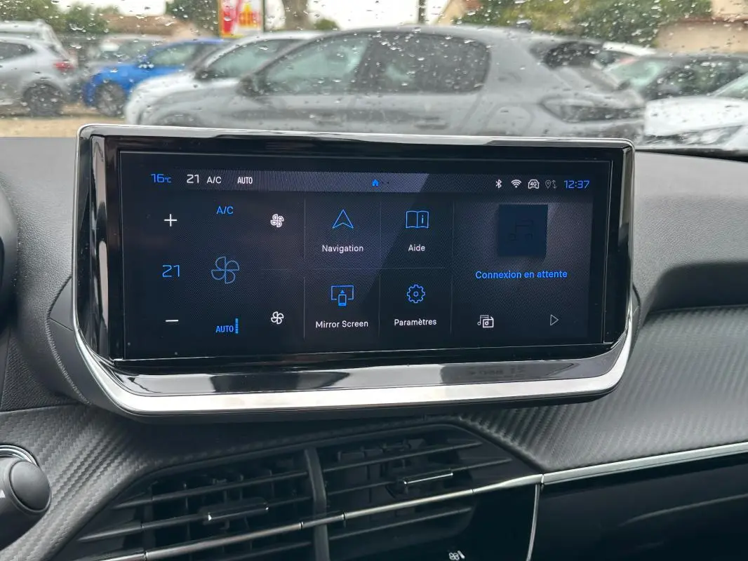 Écran tactile central du tableau de bord du Peugeot 2008 Hybrid 136 gris, avec commandes climatisation et navigation visibles.