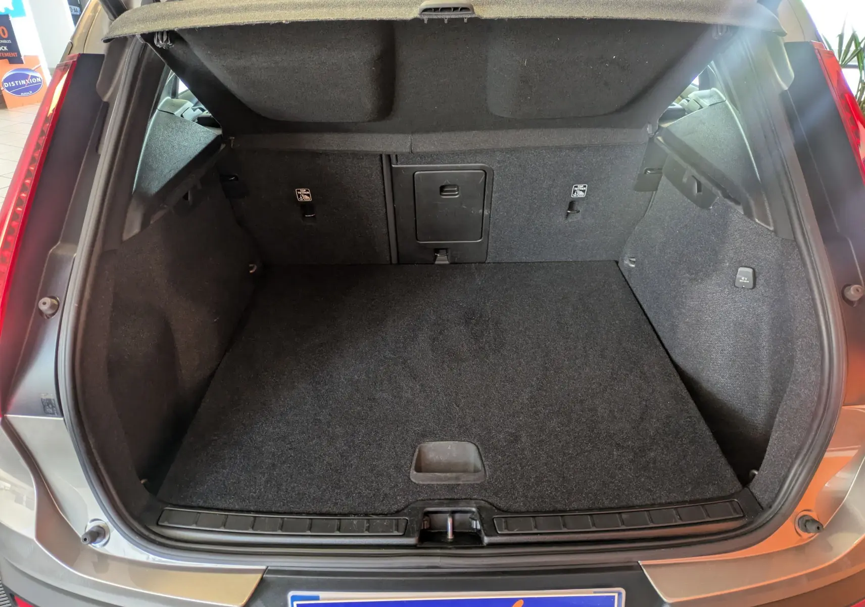 Vue arrière ouverte du coffre spacieux et propre d’un Volvo XC40 marron clair 2021 Momentum.