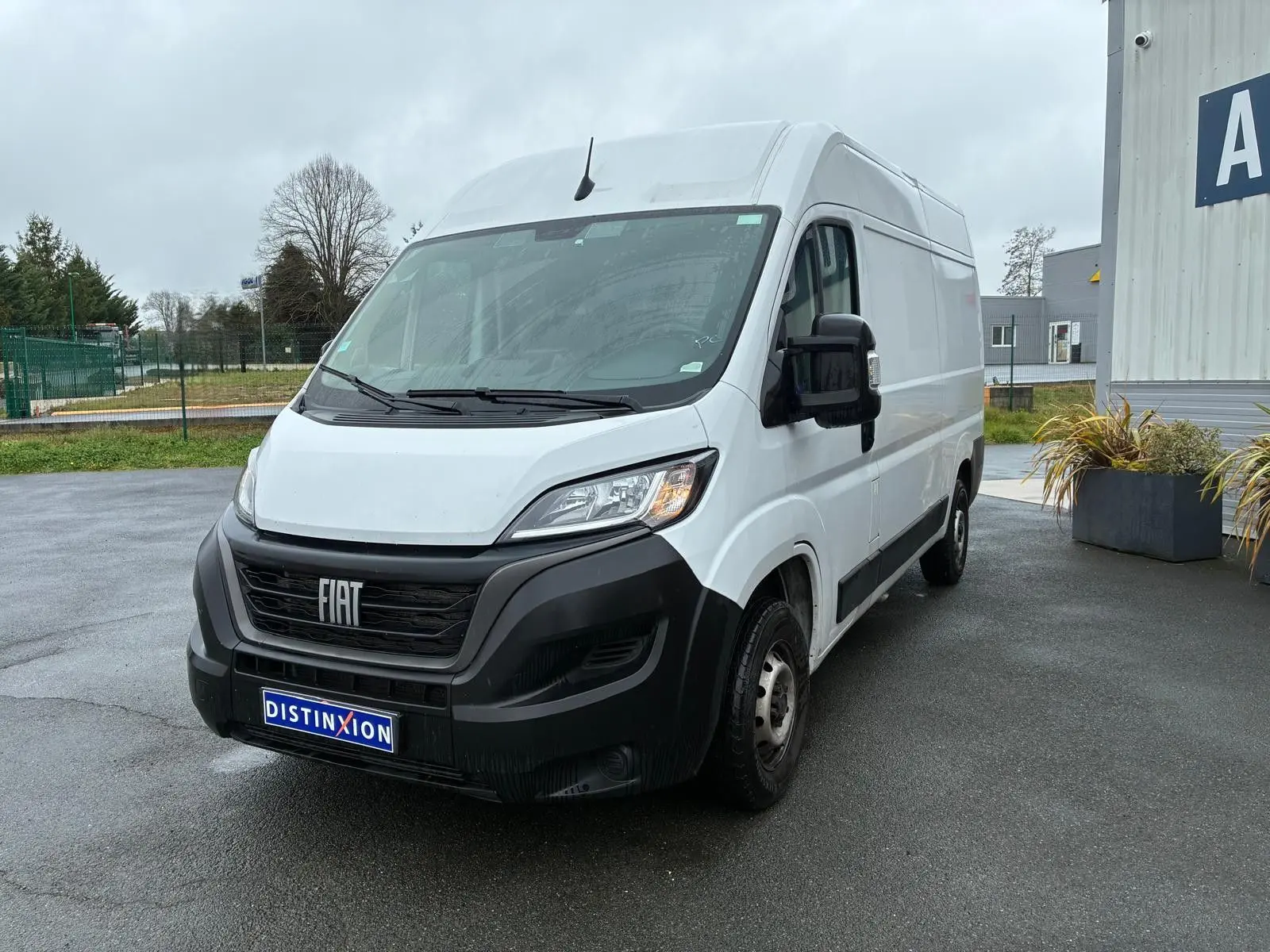 Fourgon FIAT Ducato blanc en 3/4 avant droit, avec calandre noire et plaque Distinxion visible.