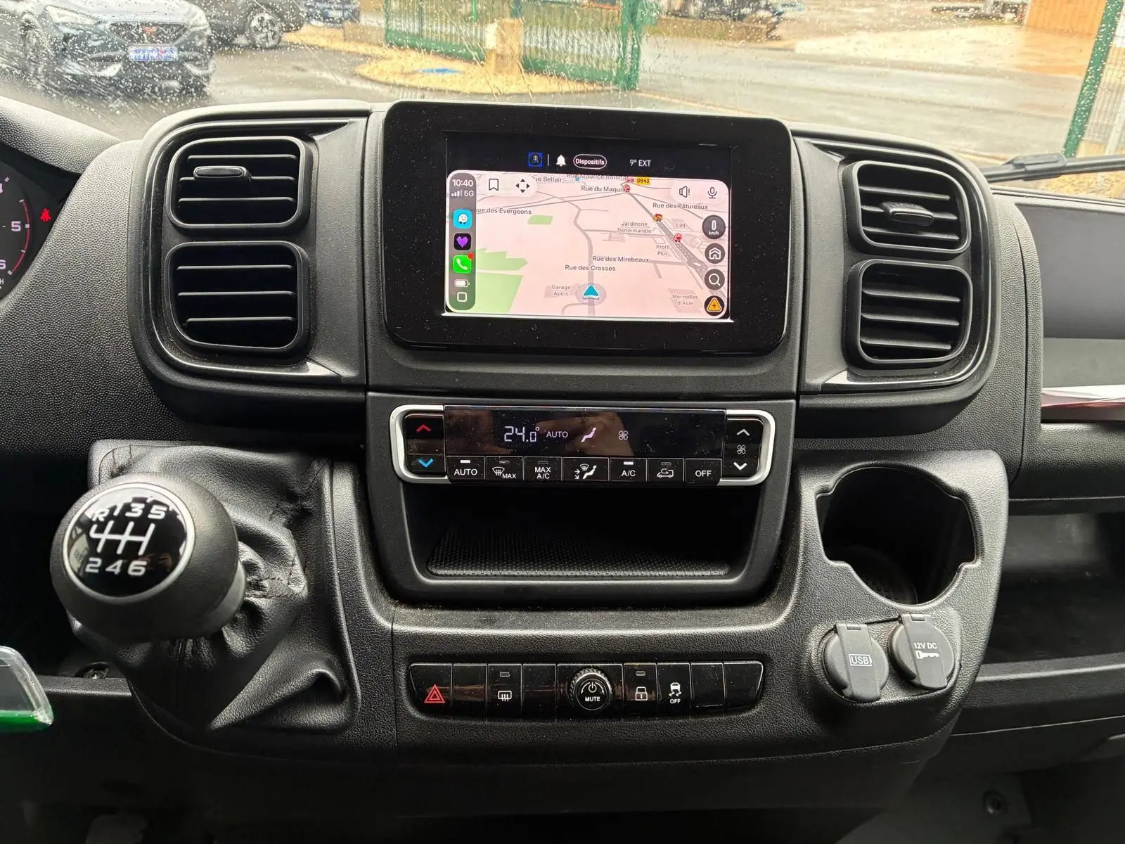 Vue intérieure centrée sur la console centrale du Fiat Ducato Fourgon 2023 avec écran tactile et levier de vitesses manuel.