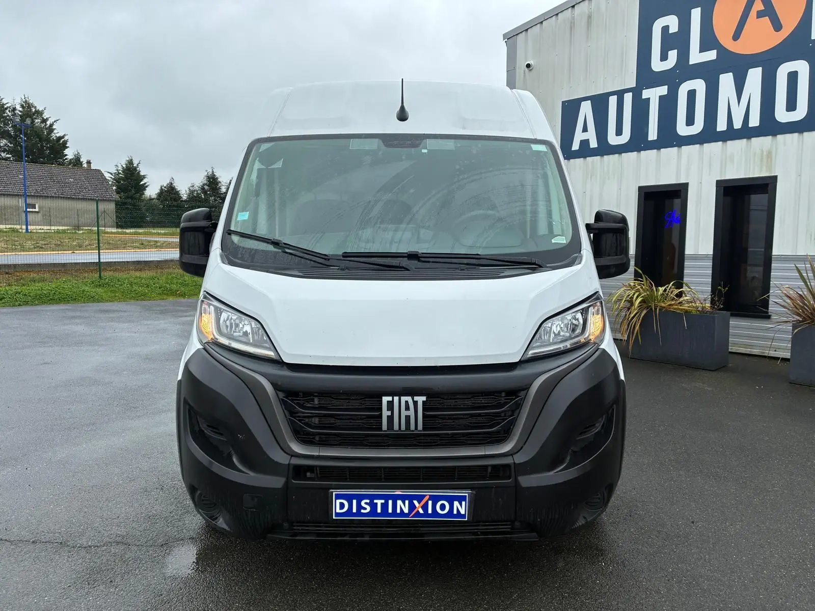Vue frontale d’un FIAT Ducato Fourgon blanc 2023 avec calandre noire et plaque Distinxion visible.