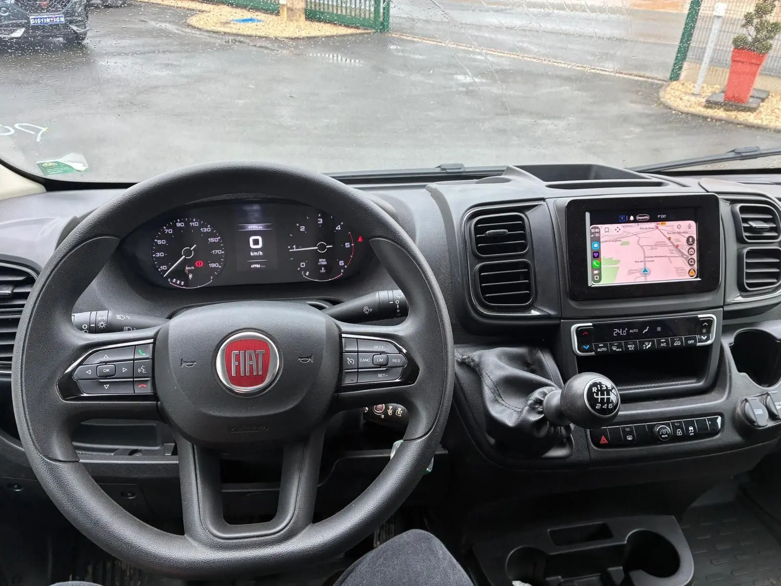 Vue intérieure du tableau de bord du Fiat Ducato Fourgon 2023, volant multifonction et écran tactile avec navigation.