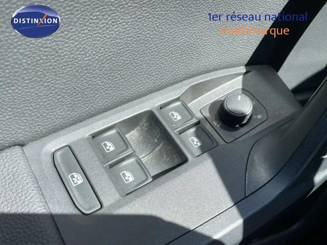 Gros plan sur les commandes des vitres électriques et rétroviseurs côté conducteur d'une SEAT Arona blanc toit noir.