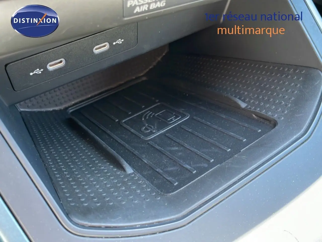 Gros plan sur la zone de recharge sans fil et ports USB du SEAT Arona blanc toit noir, intérieur noir.