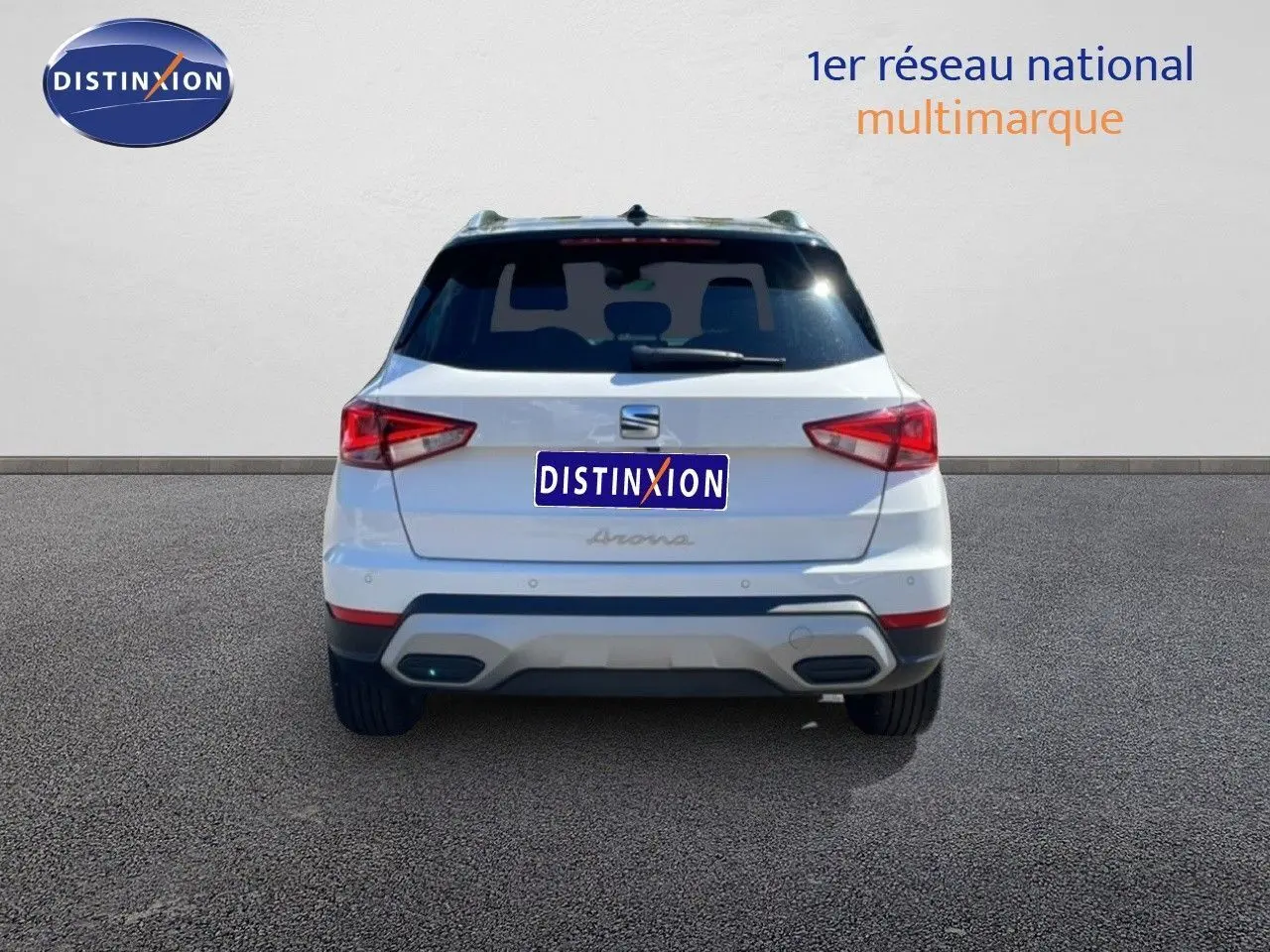 Vue arrière d'un SEAT Arona blanc avec toit noir, montrant les feux arrière et le pare-chocs arrière distinctif.