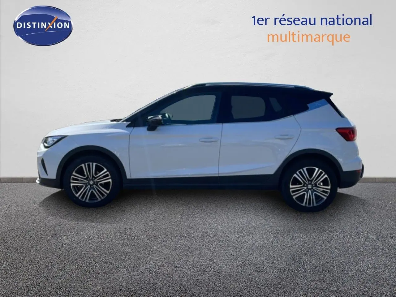Vue de profil côté gauche du SEAT Arona blanc avec toit noir, roues alliage et lignes modernes, sur fond neutre.