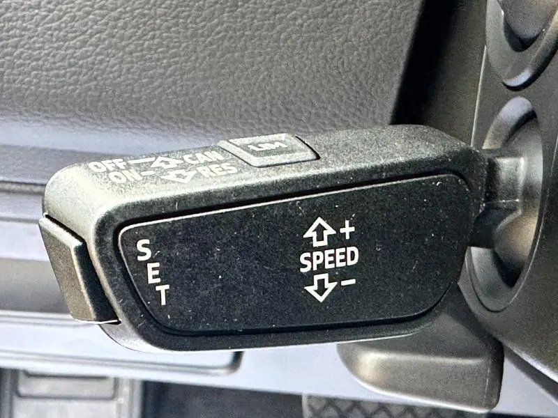 Gros plan sur la commande de régulateur de vitesse noir à l'intérieur d'une Audi A6 Avant 2019 finition S line.