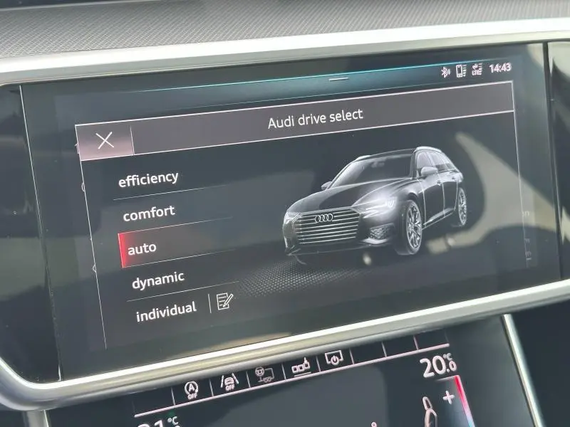Écran tactile intérieur montrant une Audi A6 Avant noir métal en 3/4 avant dans le menu Audi drive select