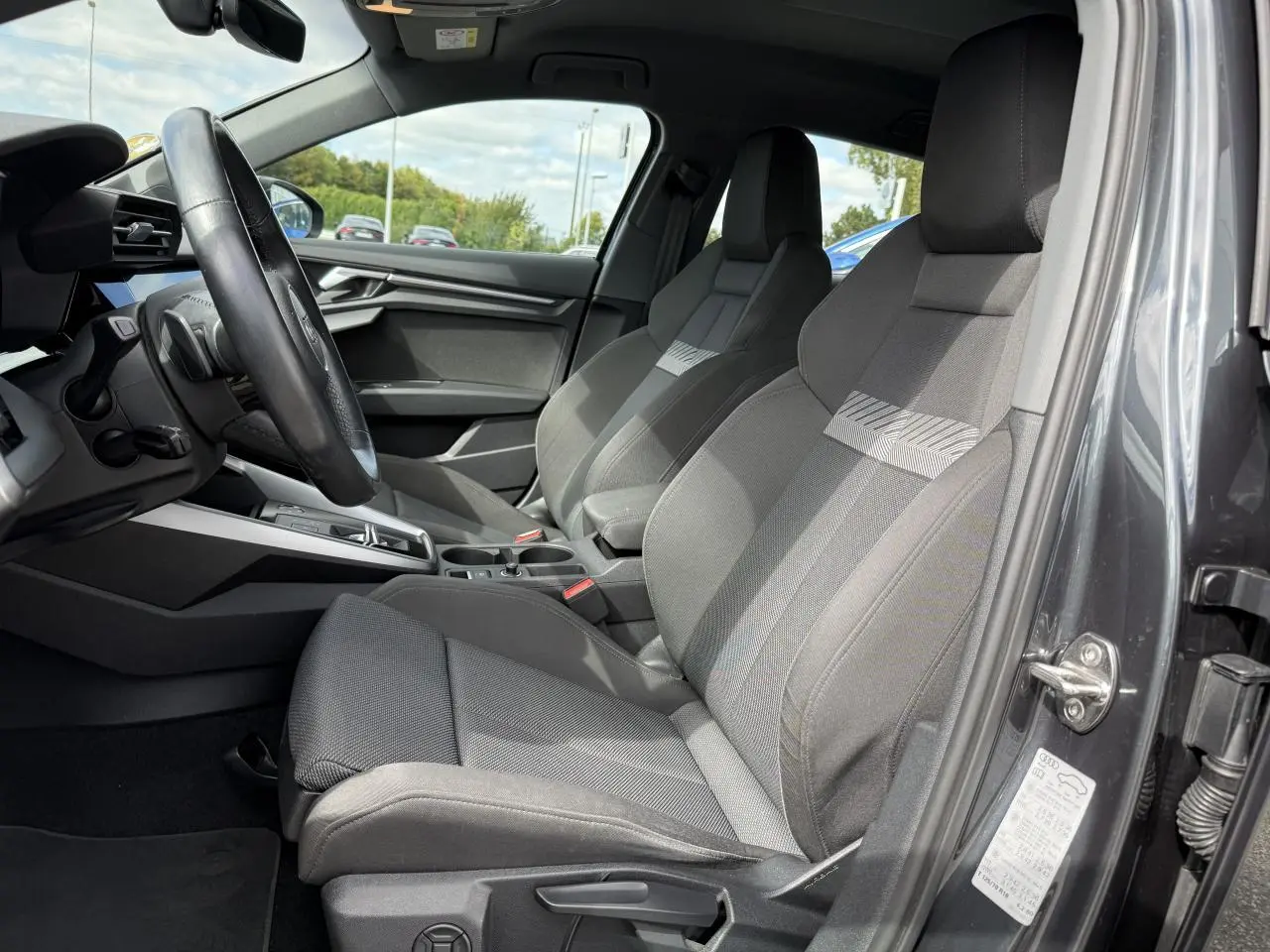 Vue intérieure côté conducteur de l'Audi A3 Sportback 2020 gris Manhattan, sièges sport et volant cuir multifonctions.