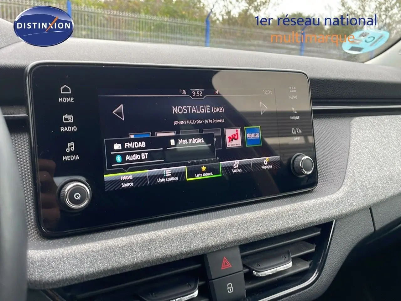 Écran tactile central du Skoda Kamiq 2024 affichant la radio DAB, avec tableau de bord gris et commandes visibles.