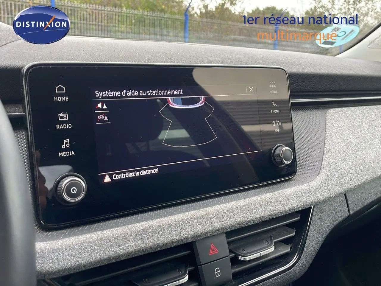 Écran tactile du système d'aide au stationnement dans l'habitacle gris du Skoda Kamiq rouge Velvet Metal 2024.