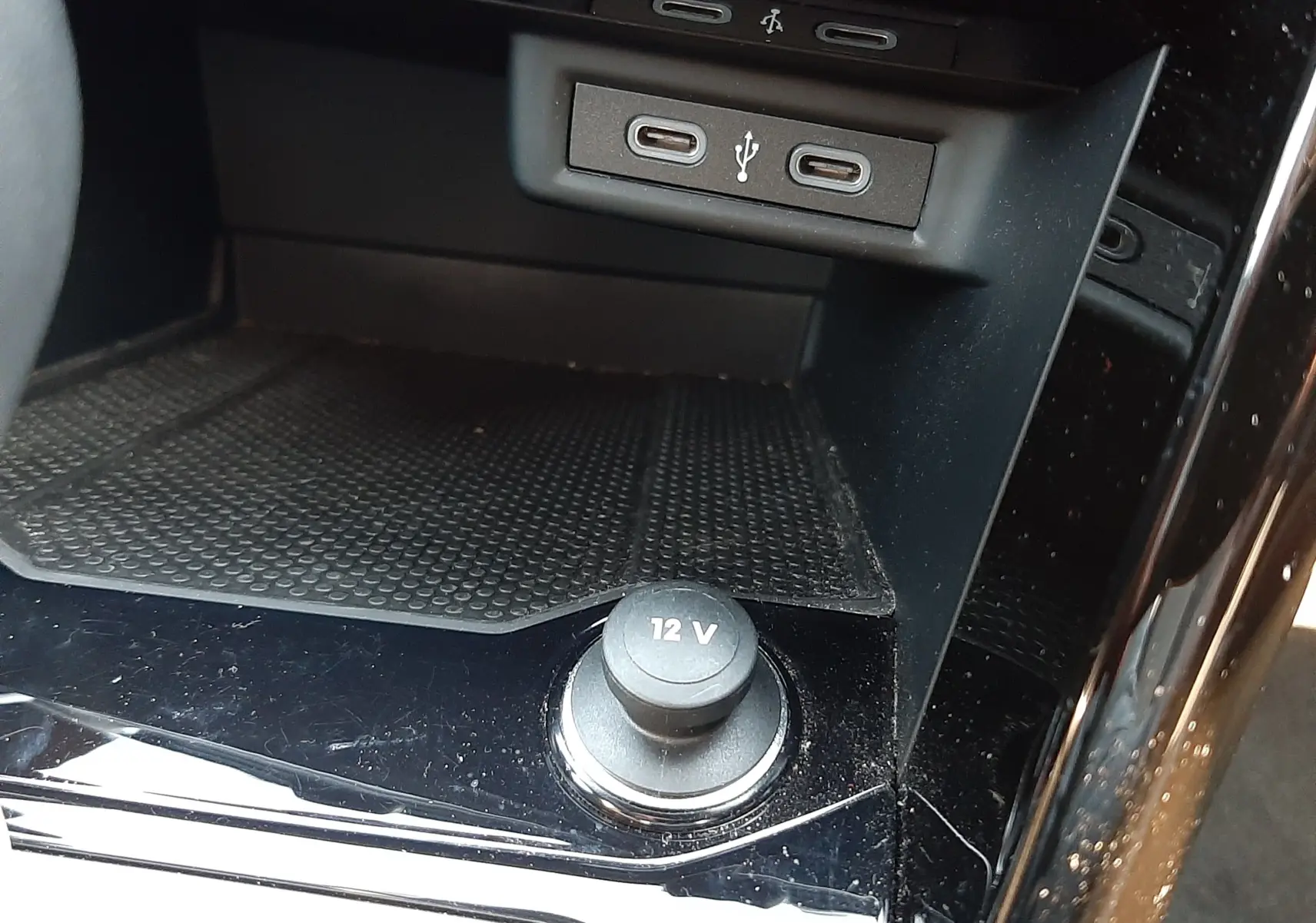 Détail de la console centrale noire du Volkswagen T-Roc 2024, avec prises USB-C et prise 12V visible.