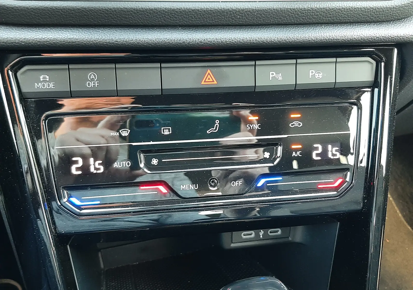 Vue rapprochée de la console centrale du Volkswagen T-Roc 2024 gris Indium, montrant les commandes de climatisation et le levier de boîte automatique.
