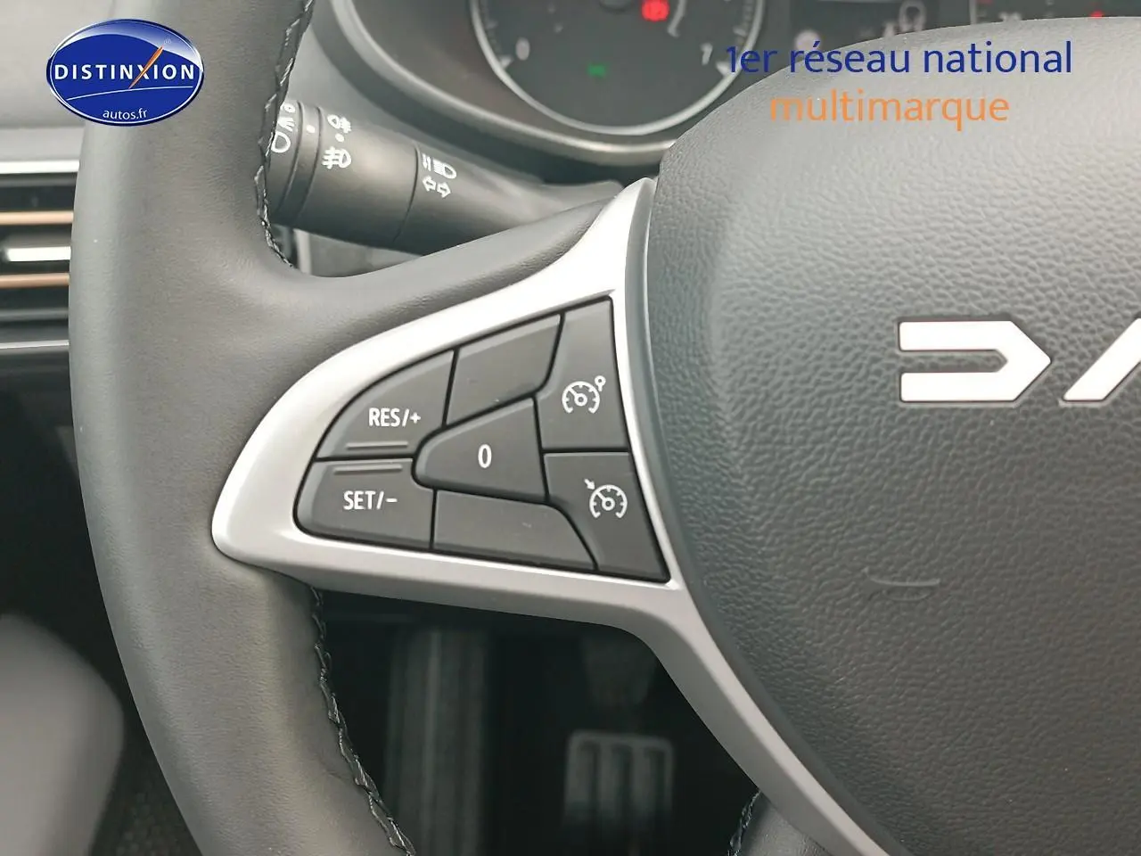 Gros plan sur la partie gauche du volant noir de la Dacia Sandero 2025 avec commandes de régulateur de vitesse intégrées.