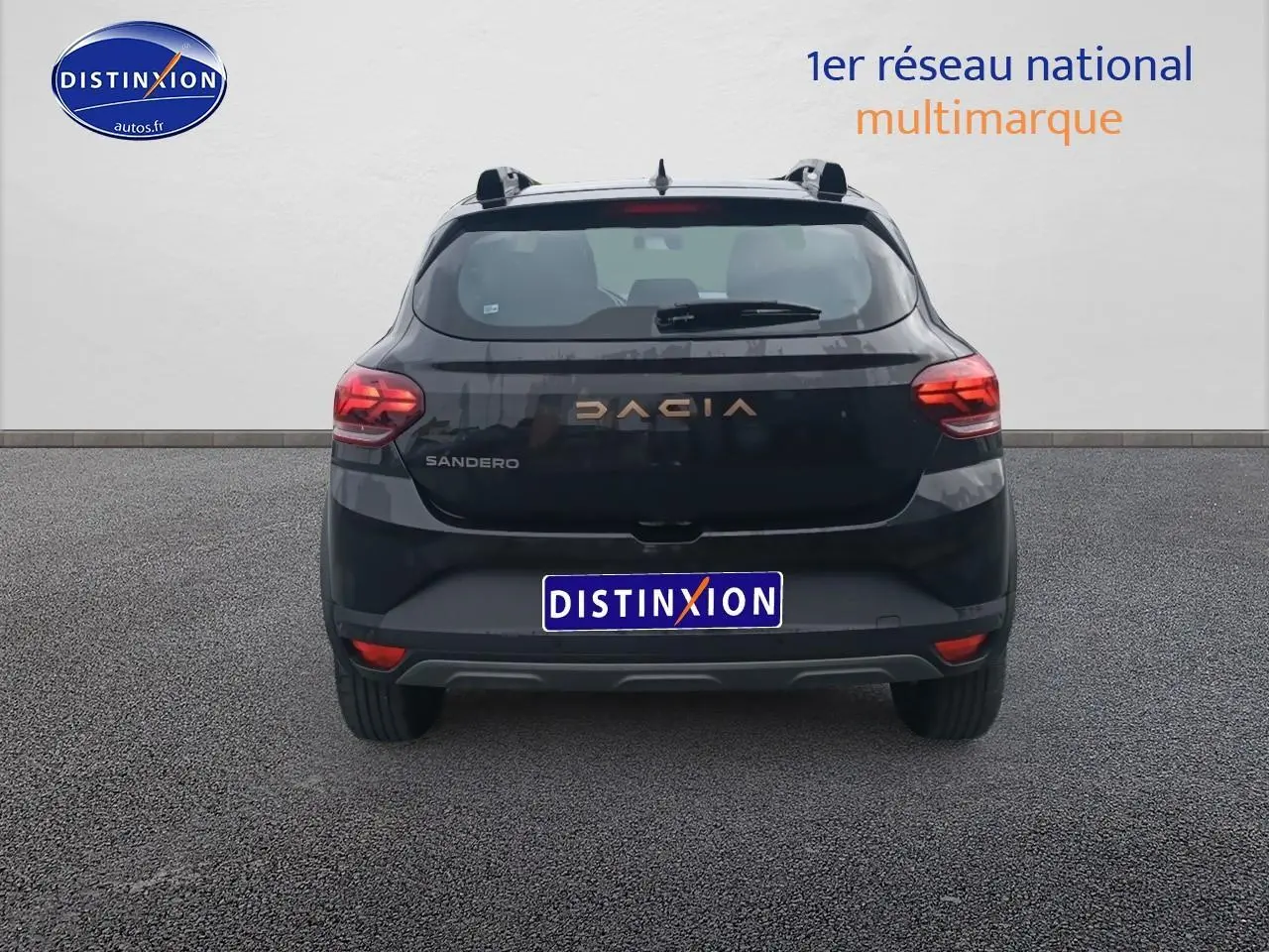 Vue arrière d'une Dacia Sandero noire 2025 avec feux rouges et logo DACIA en lettres dorées.
