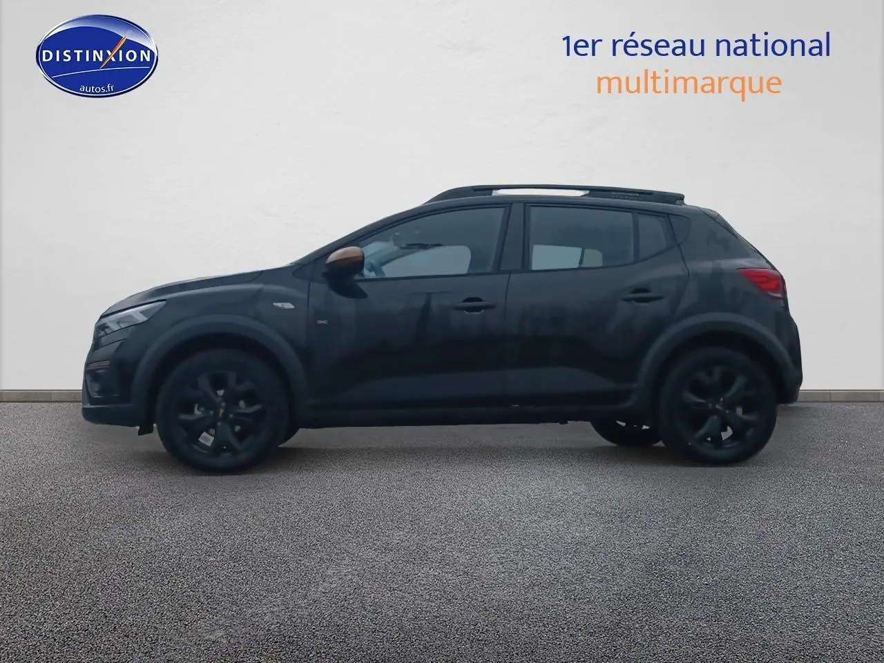 Profil côté gauche d'une Dacia Sandero Stepway noire 2025 avec barres de toit et jantes noires sur fond clair.