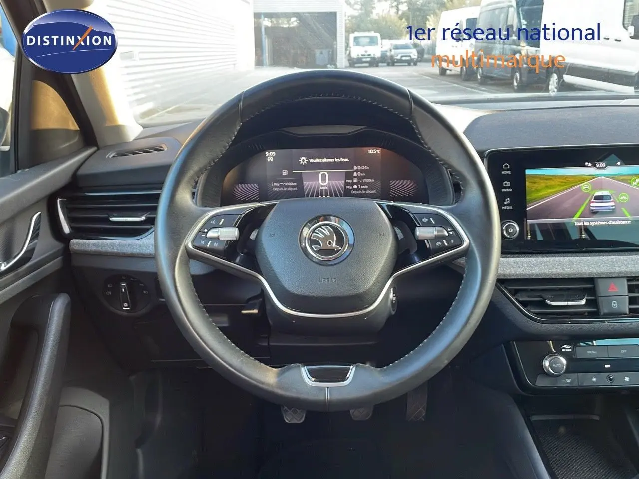 Vue intérieure centrée sur le volant cuir du Skoda Kamiq 2024 avec tableau de bord numérique et écran tactile.