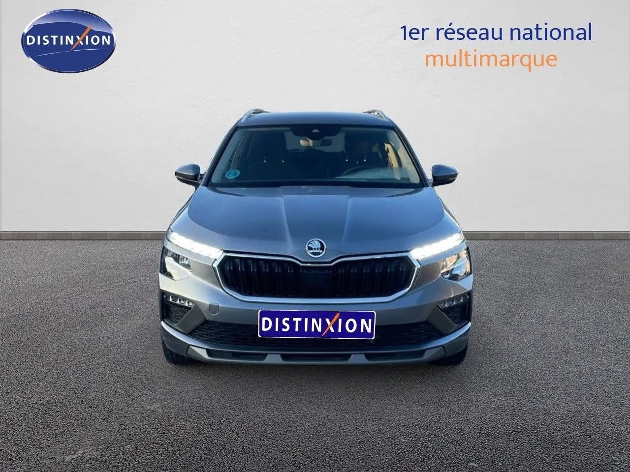 Vue frontale d'un Skoda Kamiq gris graphite métal 2024 avec phares LED allumés sur fond neutre.