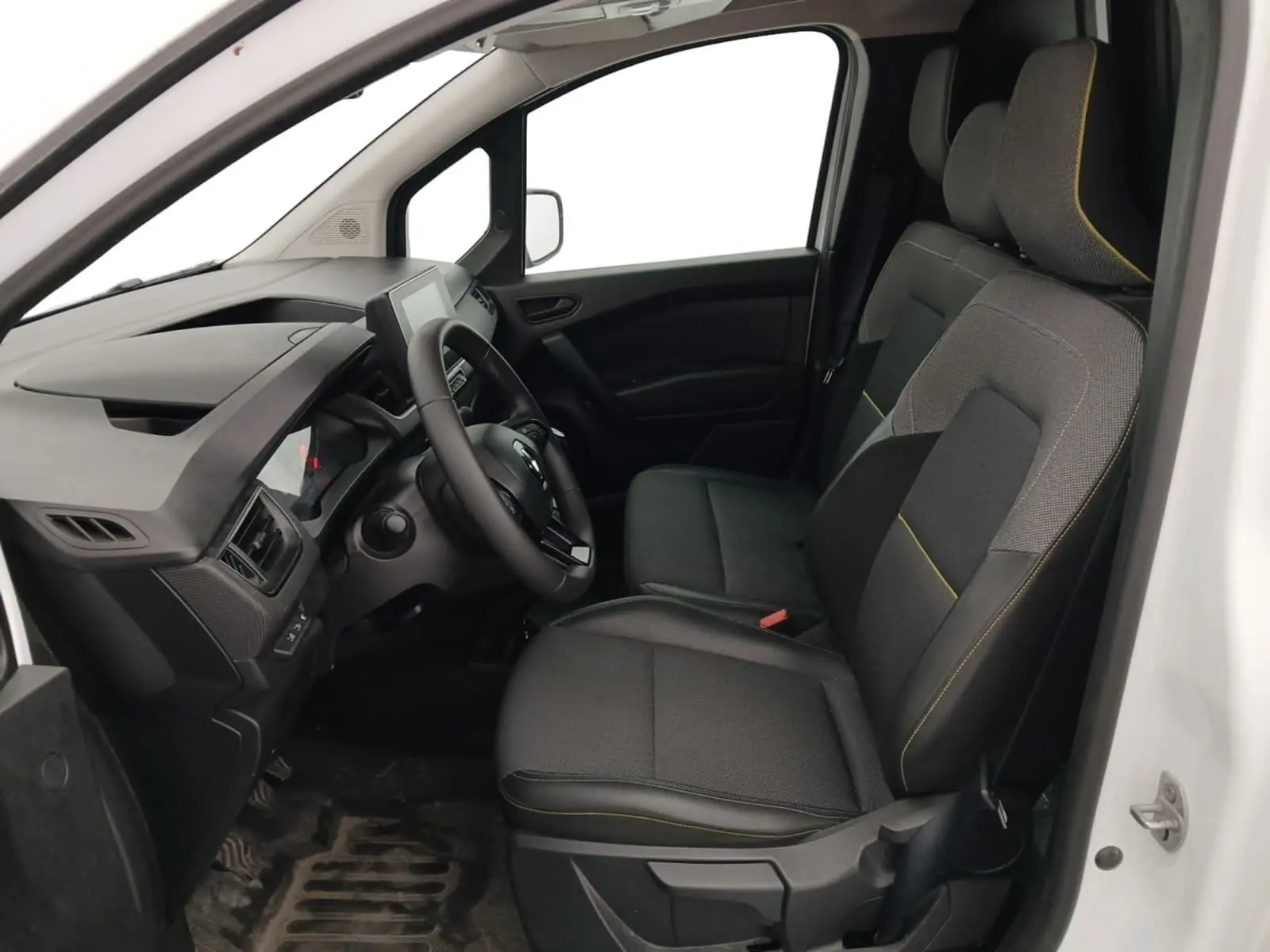 Vue intérieure côté conducteur du Renault Kangoo blanc 2024, montrant les sièges noirs avec surpiqûres jaunes et le tableau de bord moderne.