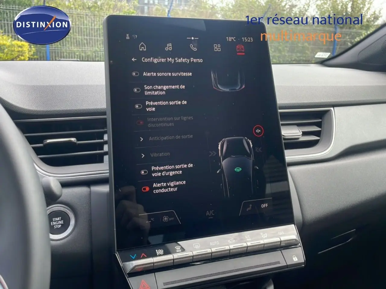 Vue intérieure centrée sur l'écran tactile vertical du tableau de bord du Renault Captur gris cassiopée métal avec toit noir.
