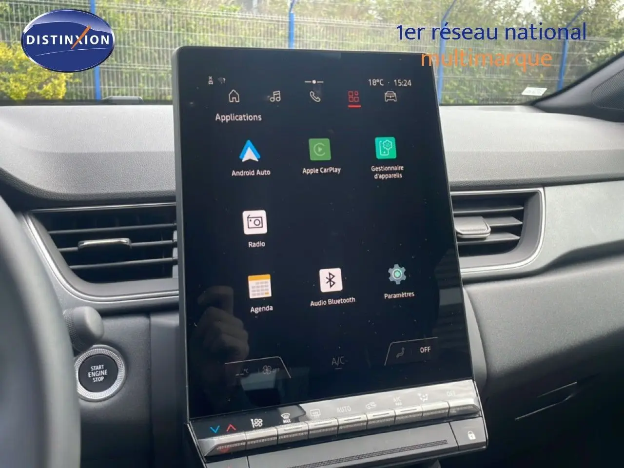 Vue intérieure centrée sur l'écran tactile vertical du tableau de bord du Renault Captur gris cassiopée métal avec toit noir.