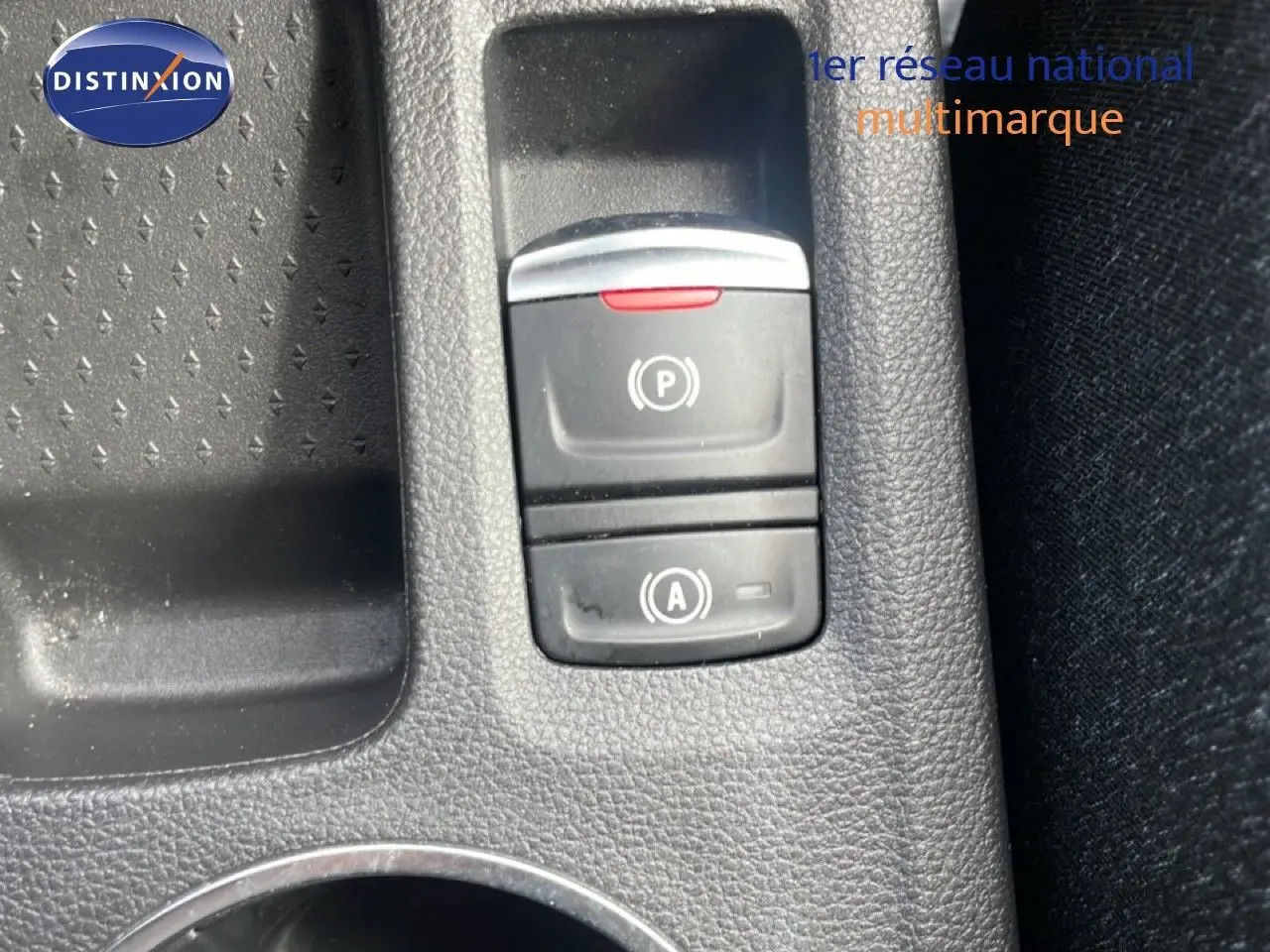 Gros plan sur les commandes de frein à main électrique et d’aide au démarrage du Renault Captur gris cassiopée métal avec toit noir.