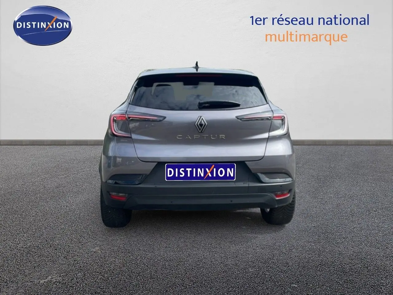 Vue arrière d'un Renault Captur gris cassiopée métal avec toit noir, mettant en valeur ses feux LED fins et son logo central.