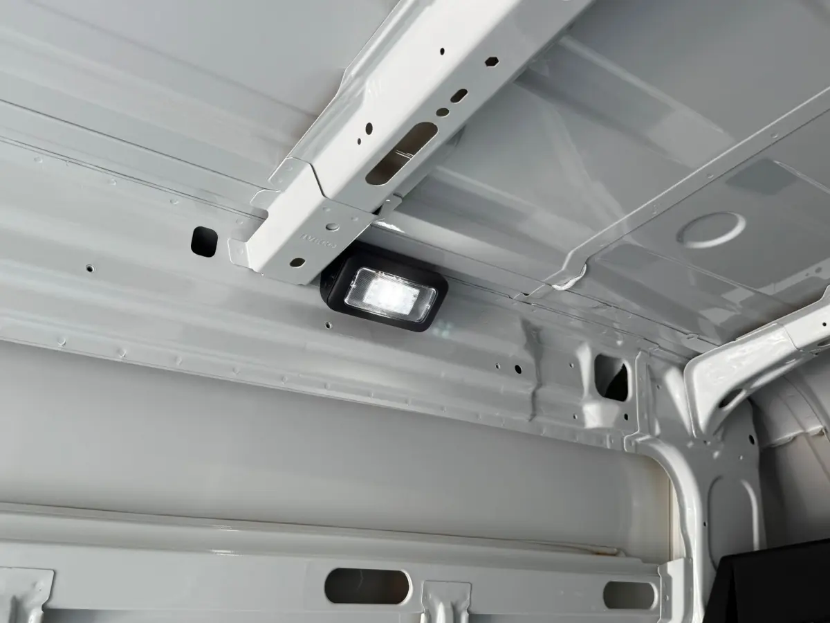 Vue intérieure du plafond blanc du fourgon Iveco Daily 2.3 35S16 V12 avec éclairage LED intégré.