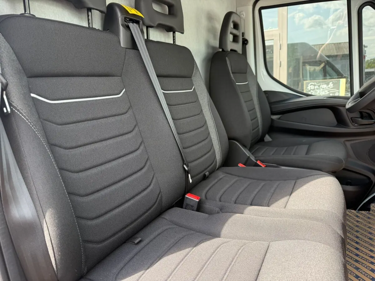 Vue intérieure côté droit montrant les sièges avant gris foncé du fourgon Iveco Daily 2.3 35S16 V12 blanc de 2026.