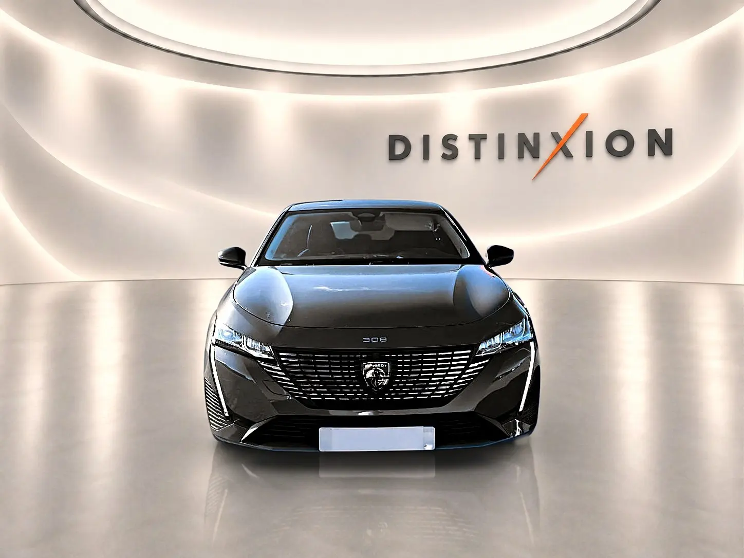Vue avant d'une Peugeot 308 gris selenium avec calandre distinctive et phares LED dans un showroom lumineux.