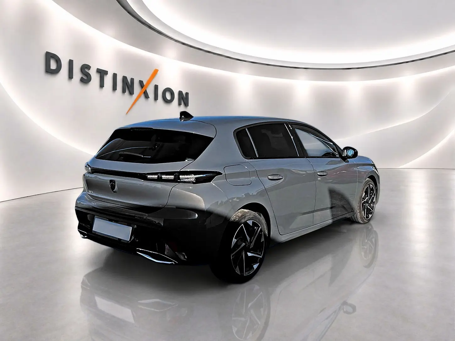 Vue 3/4 arrière droite d'une Peugeot 308 gris selenium avec jantes alu noires et vitres arrière surteintées dans un studio lumineux.