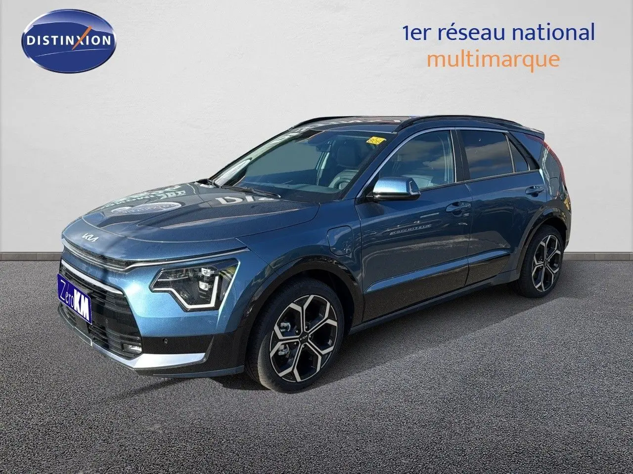 KIA NIRO hybride rechargeable bleu minéral métal en 3/4 avant droit avec jantes bi-ton et phares LED distinctifs.