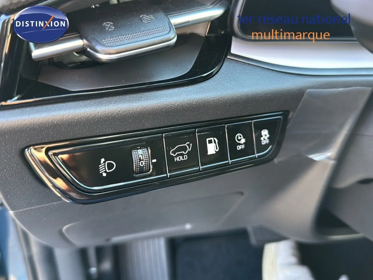 Gros plan sur les commandes noires du tableau de bord du Kia Niro bleu minéral 2025, côté conducteur.