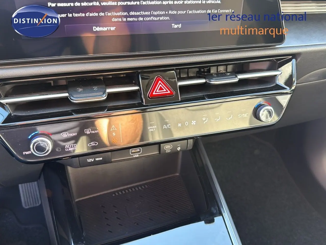 Tableau de bord et console centrale du Kia Niro hybride rechargeable 2025, avec commandes climatisation et port USB visibles.