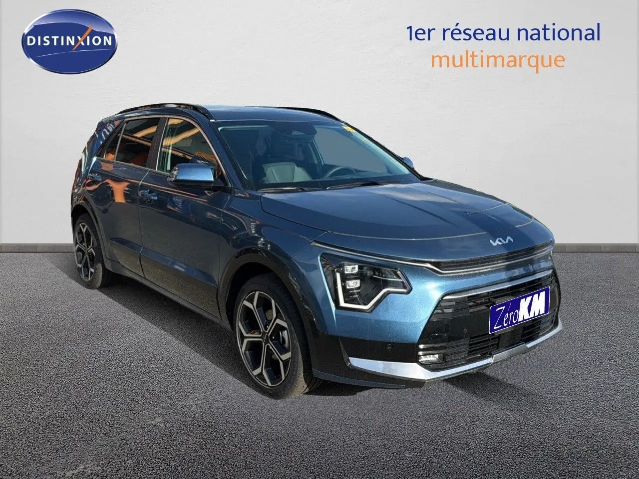 KIA NIRO hybride rechargeable bleu minéral metal vu en 3/4 avant droit avec jantes bi-ton et calandre noire.