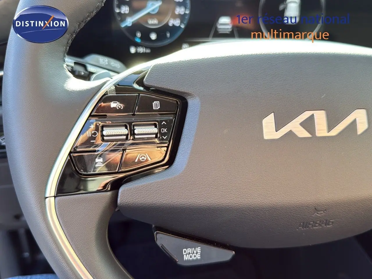 Gros plan sur le volant cuir noir du Kia Niro 2025 avec commandes intégrées et logo KIA visible au centre.